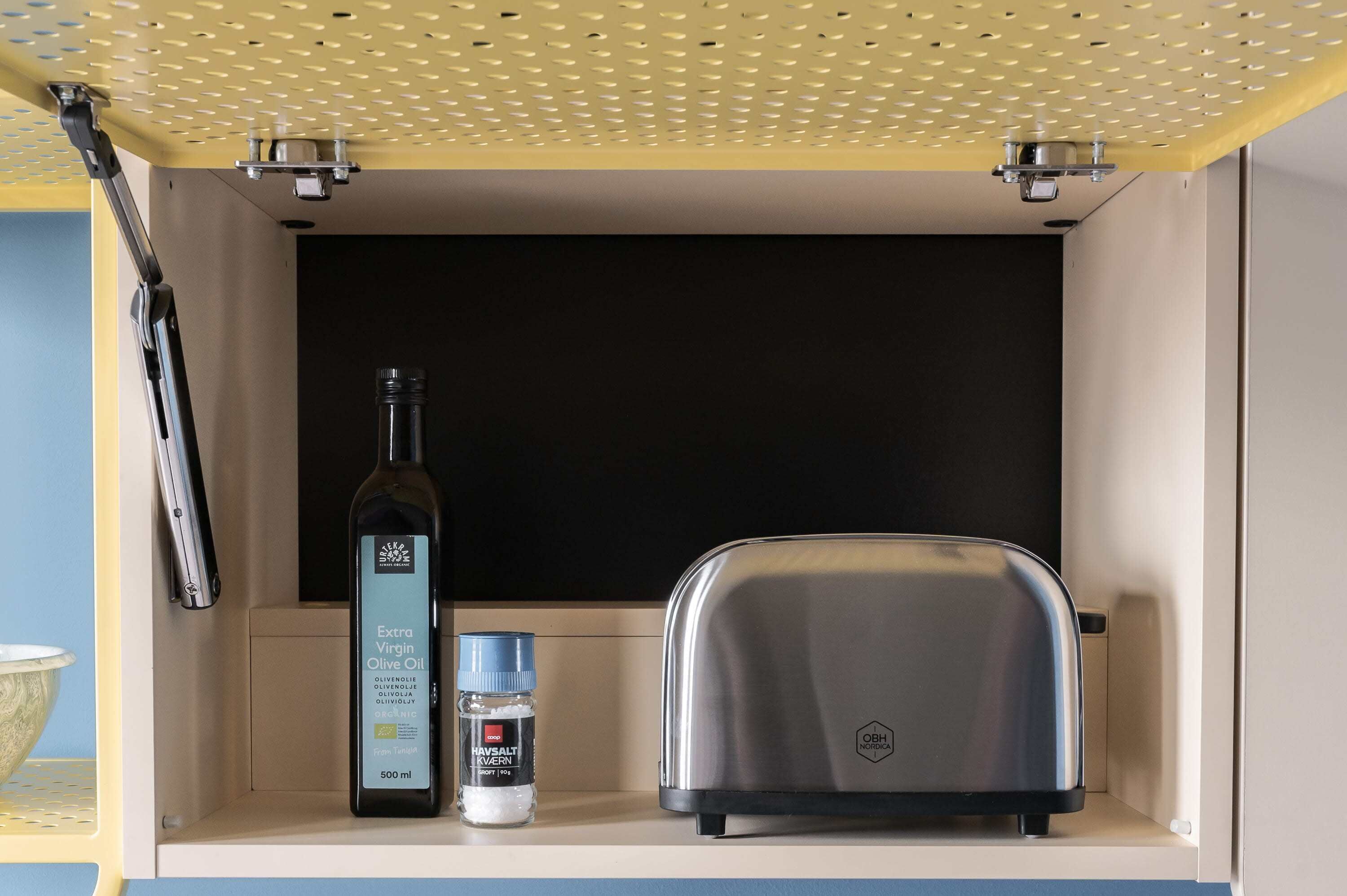 A kitchen counter with a toaster, a bottle of olive oil, and a container of salt.
