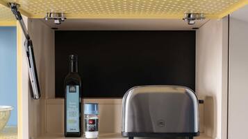 A kitchen counter with a toaster, a bottle of olive oil, and a container of salt.