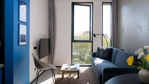 A modern living room with a sofa, a chair, a coffee table, and a TV. - Århus North 1BR Apartment by Daniel&Jacob's (Aarhus)