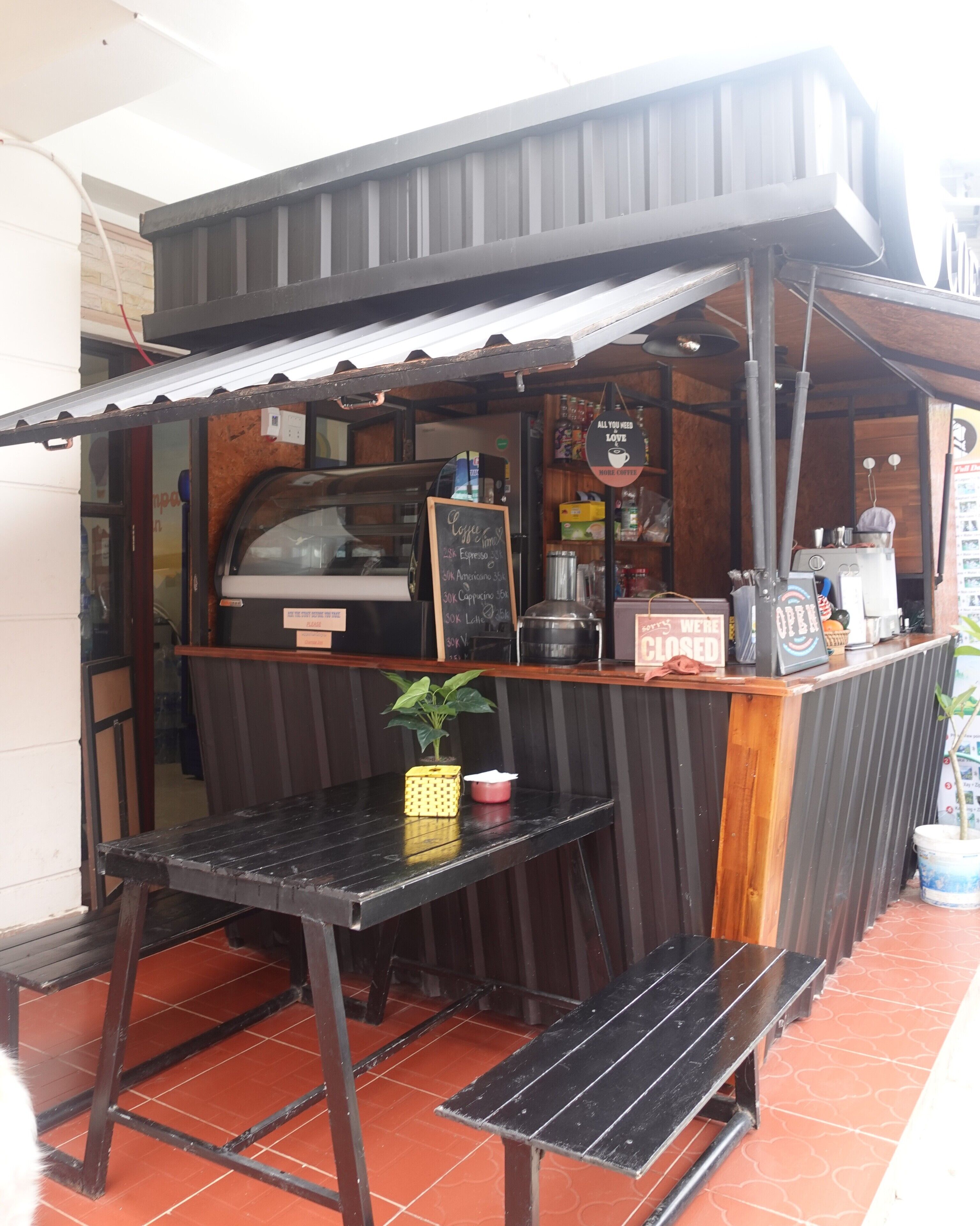 Ett litet kafé med en bardisk, en menytavla och ett område med sittplatser.