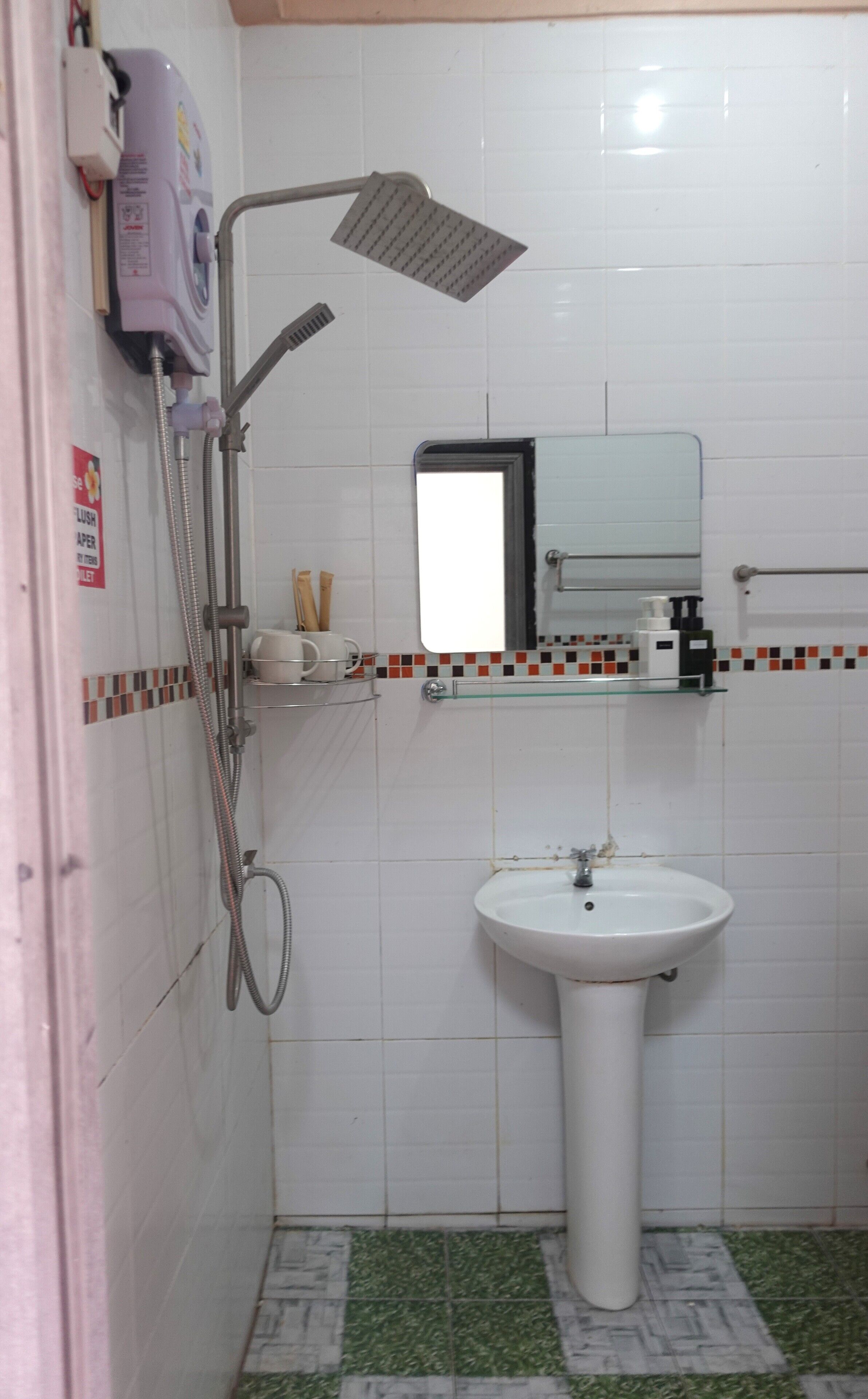 Ein Badezimmer mit Dusche, Waschbecken und Spiegel.