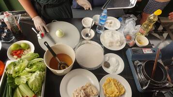 Uma mesa com diversos alimentos e acompanhamentos, incluindo arroz, vegetais e uma tigela de sopa.
