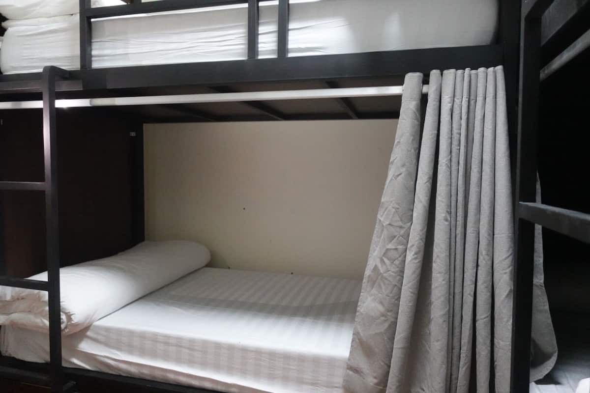 A bunk bed with a mattress and a curtain.