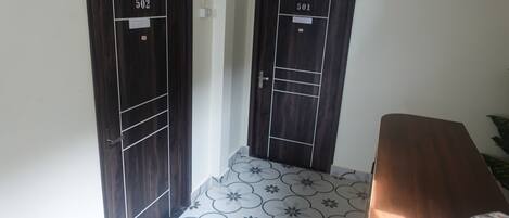 A hallway with two doors labeled 502 and 501, a patterned floor, and a wooden bench.