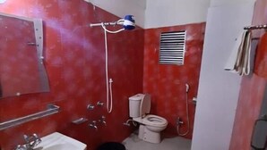 A compact bathroom with a sink, toilet, and shower.