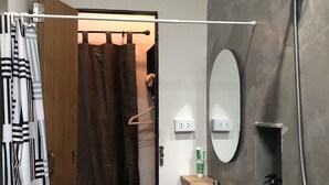 Une salle de bain équipée d’une douche, d’un lavabo, d’un miroir et d’un porte-serviettes.