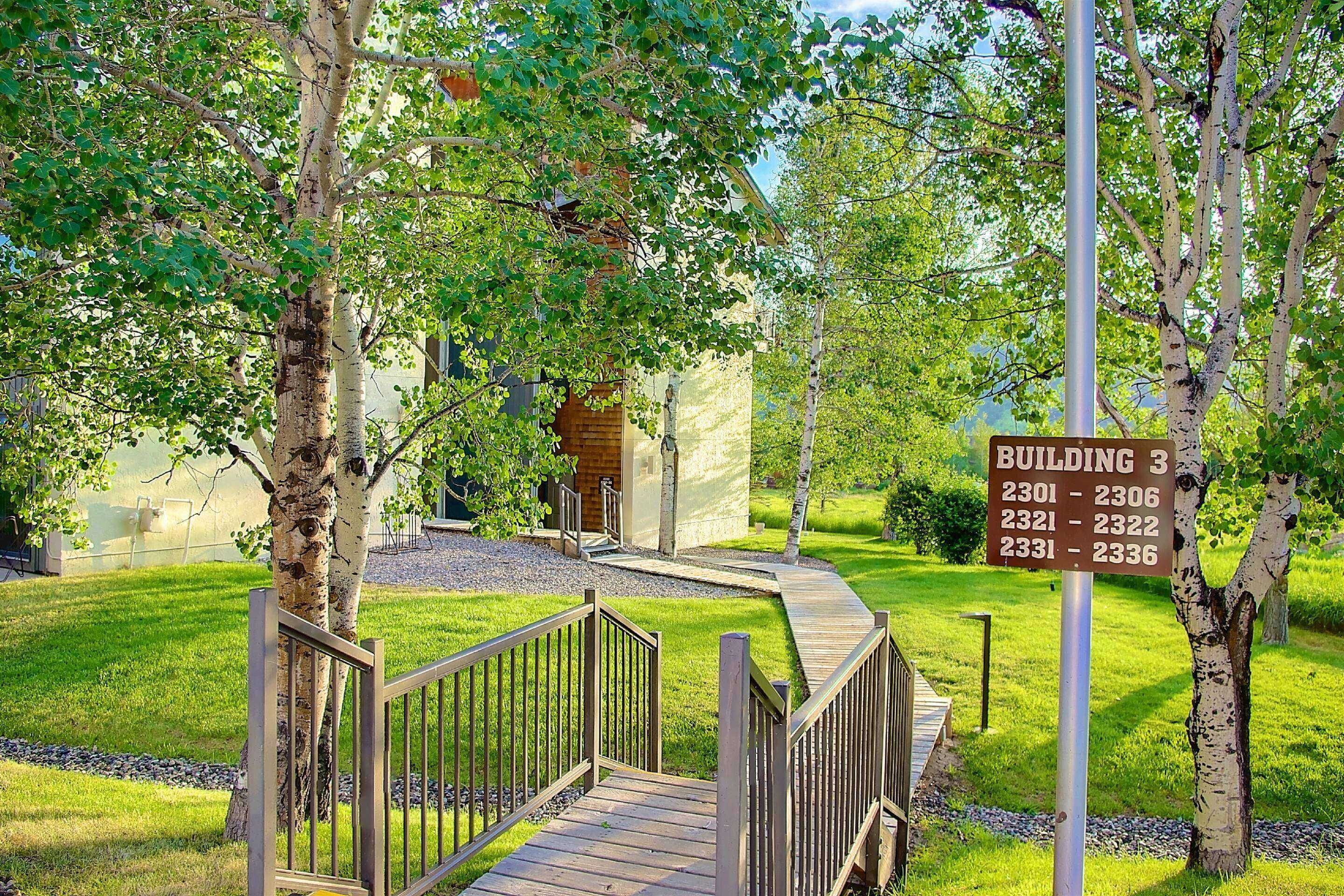 A wooden pathway leading to a building with a sign indicating Building 3 and room numbers 2301-2336.