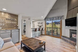 A modern living space with a kitchen, dining area, and a fireplace. - Updated-SkiLocker-Heated Pool-HotTub-Near Free Bus (Steamboat Springs)