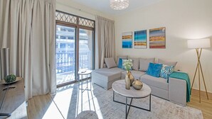 A modern living room with a sofa, a coffee table, and artwork on the wall. - Stylish 2BR with Balcony Near Dubai Mall & Burj Khalifa (Oldtown Dubai)