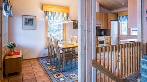 Un intérieur en bois comprenant un coin repas, une cuisine et un escalier.