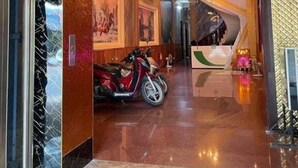 A hotel lobby with a polished floor, a red scooter, and a staircase leading to a reception area. - Hoang Gia Hotel Binh Duong by Bay Luxury (Ho Chi Minh City)