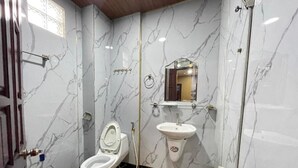 A bathroom with a toilet, sink, and shower. - Hoang Gia Hotel Binh Duong by Bay Luxury (Ho Chi Minh City)