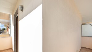 Um corredor com uma porta que dá para uma varanda.
