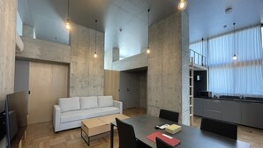 Une cuisine moderne avec un coin repas, un canapé et une table avec des chaises.