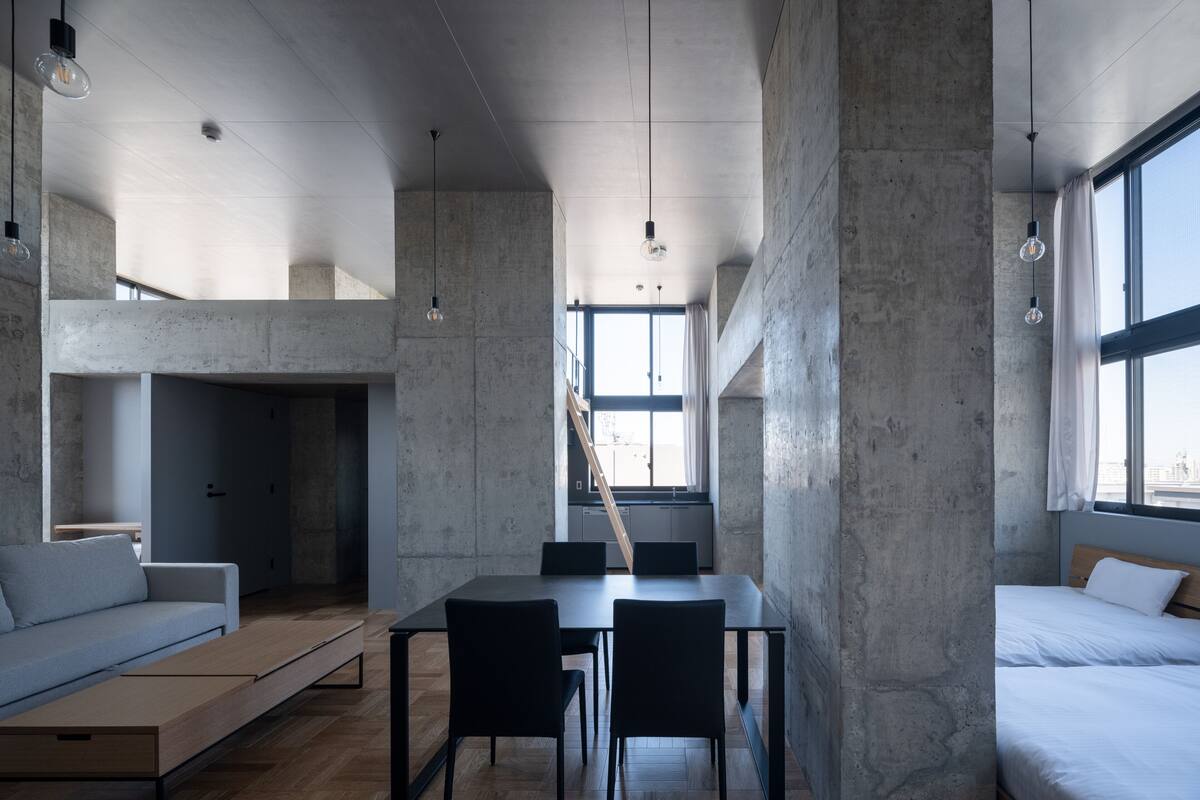 Um interior moderno com área de jantar, sofá e cama.