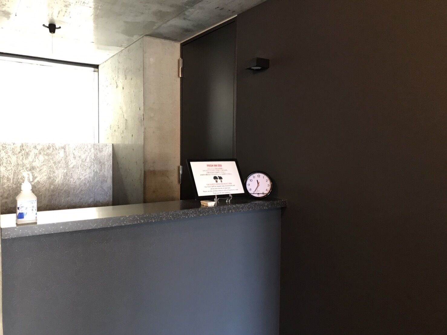 Un comptoir d’accueil avec une horloge et un panneau.