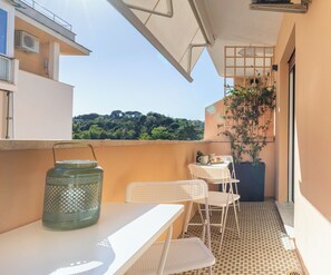 A balcony with a table, chairs, a potted plant, and a hanging plant. - Silverius- Rome's Delightful Lodges {Vatican} Elegant 2 rooms 1 bath kitchen (Roma)