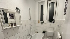 Un bagno moderno con vasca, lavabo, water e specchio.