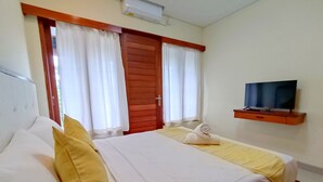 A hotel room with two beds, a TV on a wooden shelf, and a window with curtains. - Ananda's Sanur (Denpasar)