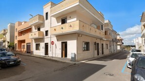 A multi-story residential building with balconies, a no-entry sign, and parked cars on a clear day. - 3781 Appartamenti Giulia - Trilo PT by Barbarhouse (Otranto)