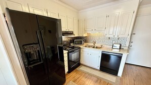 A kitchen with white cabinets, a black refrigerator, a microwave, an oven, and a dishwasher.