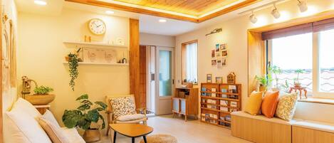 Un salon chaleureux avec un plafond en bois, un canapé, une petite table et une bibliothèque.