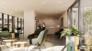 Un vestíbulo moderno con zonas de estar, mostrador de recepción y amplias ventanas.