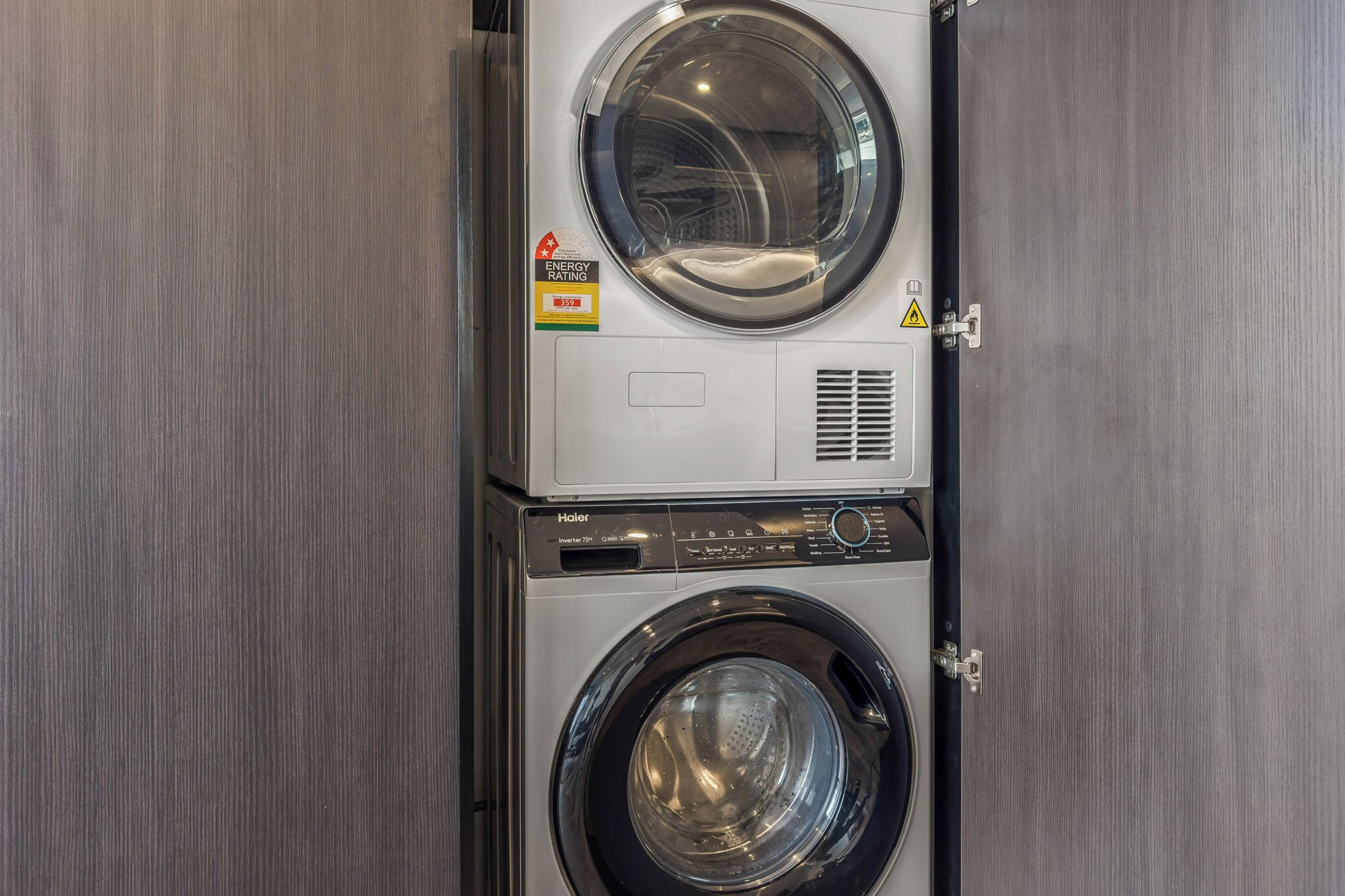 A front-loading washer and dryer unit with a visible energy efficiency rating sticker.