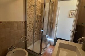 Ein Badezimmer mit Duschkabine, Badewanne und Waschbecken.