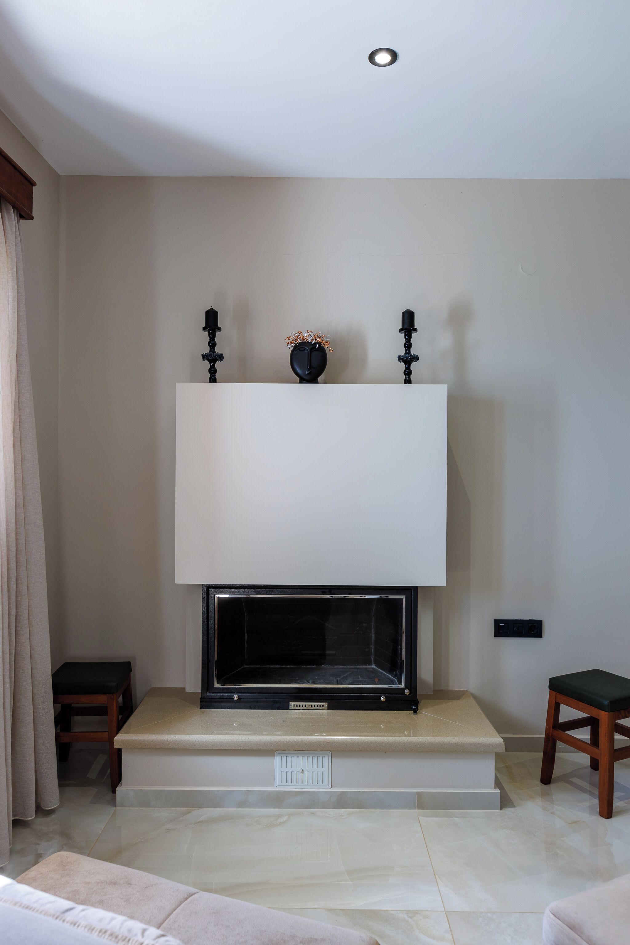 Una sala de estar moderna con chimenea, un televisor de pantalla plana montado encima y un diseño minimalista.