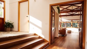 Un escalier en bois mène à une pièce d’où l’on peut admirer le paysage extérieur.