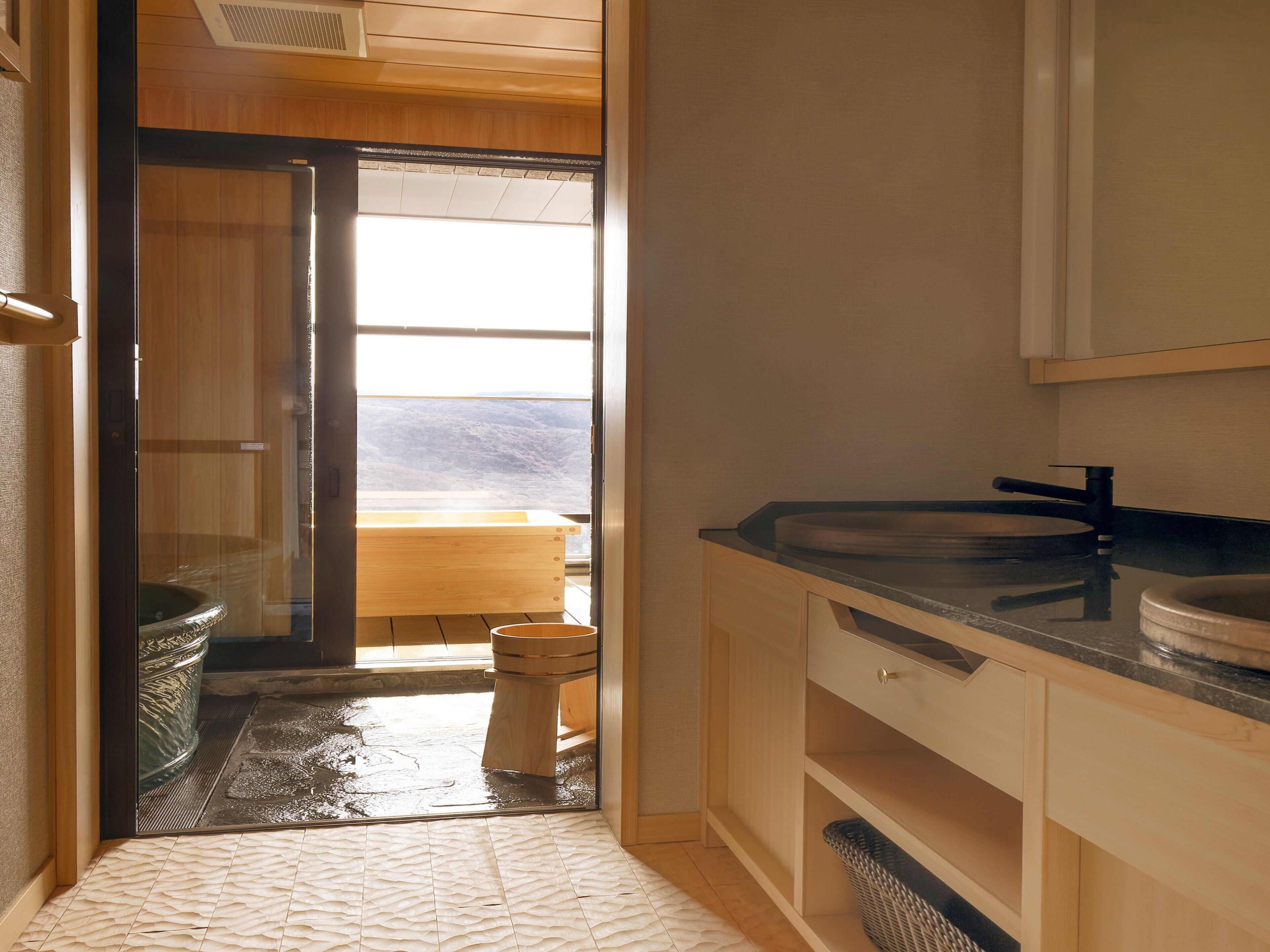 A bathroom with a wooden vanity, a sink, and a toilet.