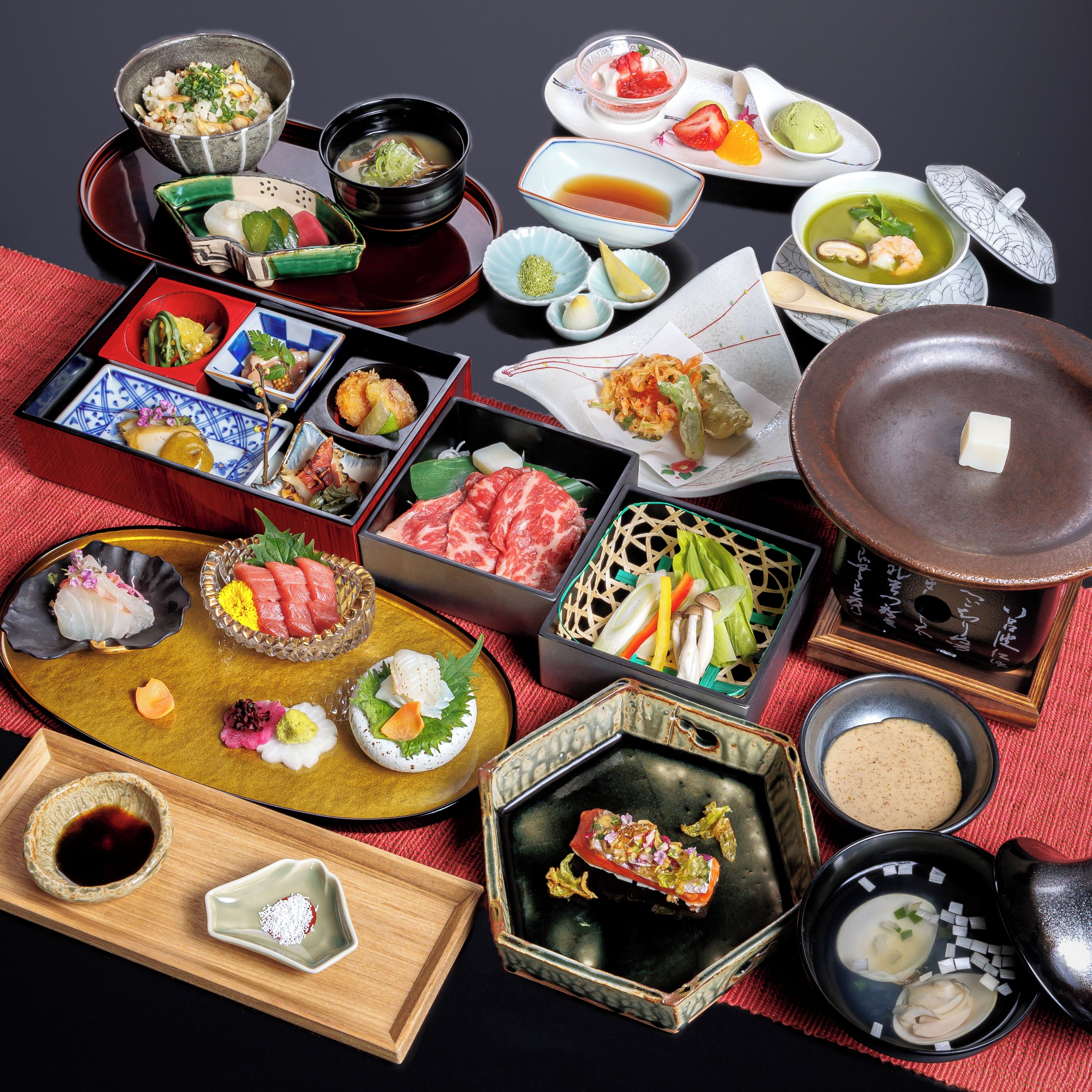 A variety of Japanese dishes arranged on a table, including sushi, sashimi, and other delicacies.