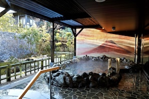 A hot spring area with stone flooring, wooden railings, and a view of a mountain through a large window. - Hotel Mori no Kaze Hakone Sengokuhara (Hakone)