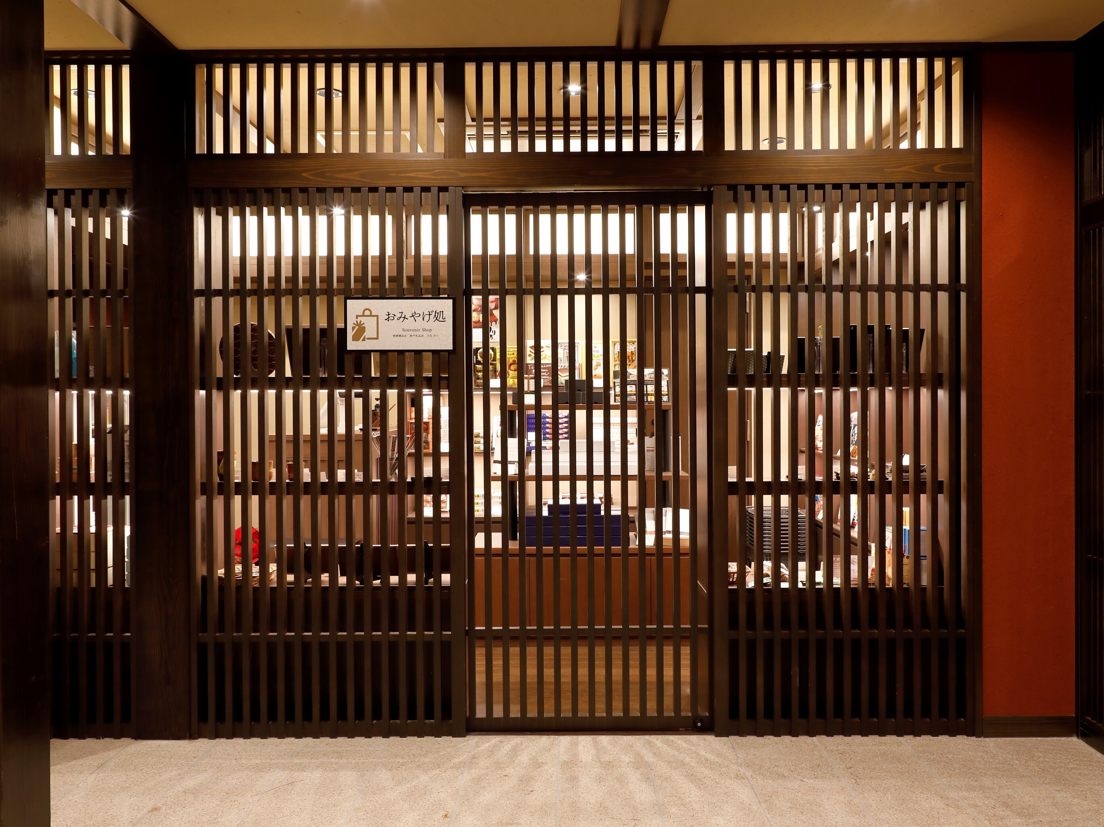 A traditional Japanese-style room with tatami flooring, a shoji screen door, and a view of a bookstore in the background.