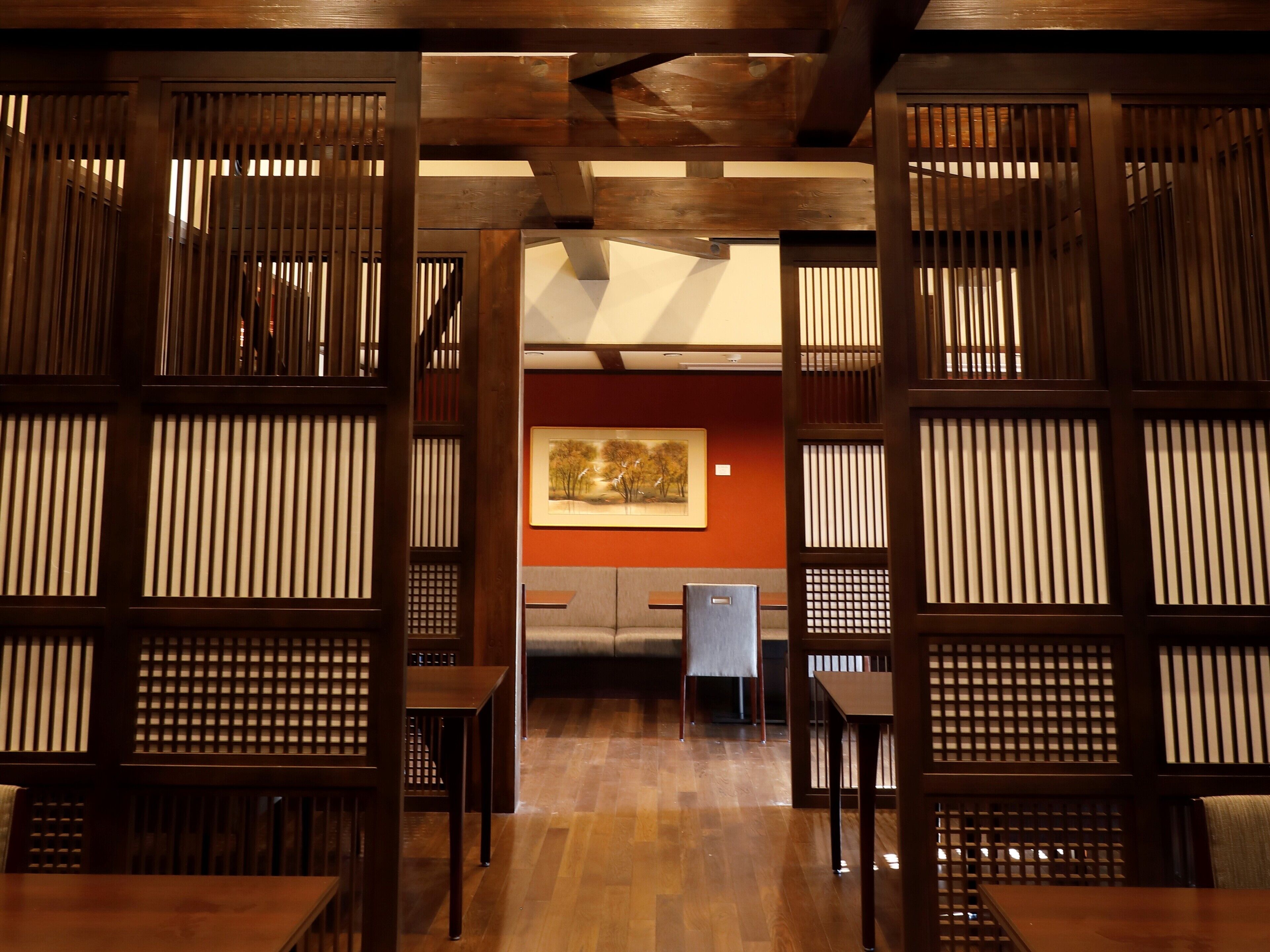 A traditional Japanese-style room with tatami flooring, low wooden tables, and sliding doors.