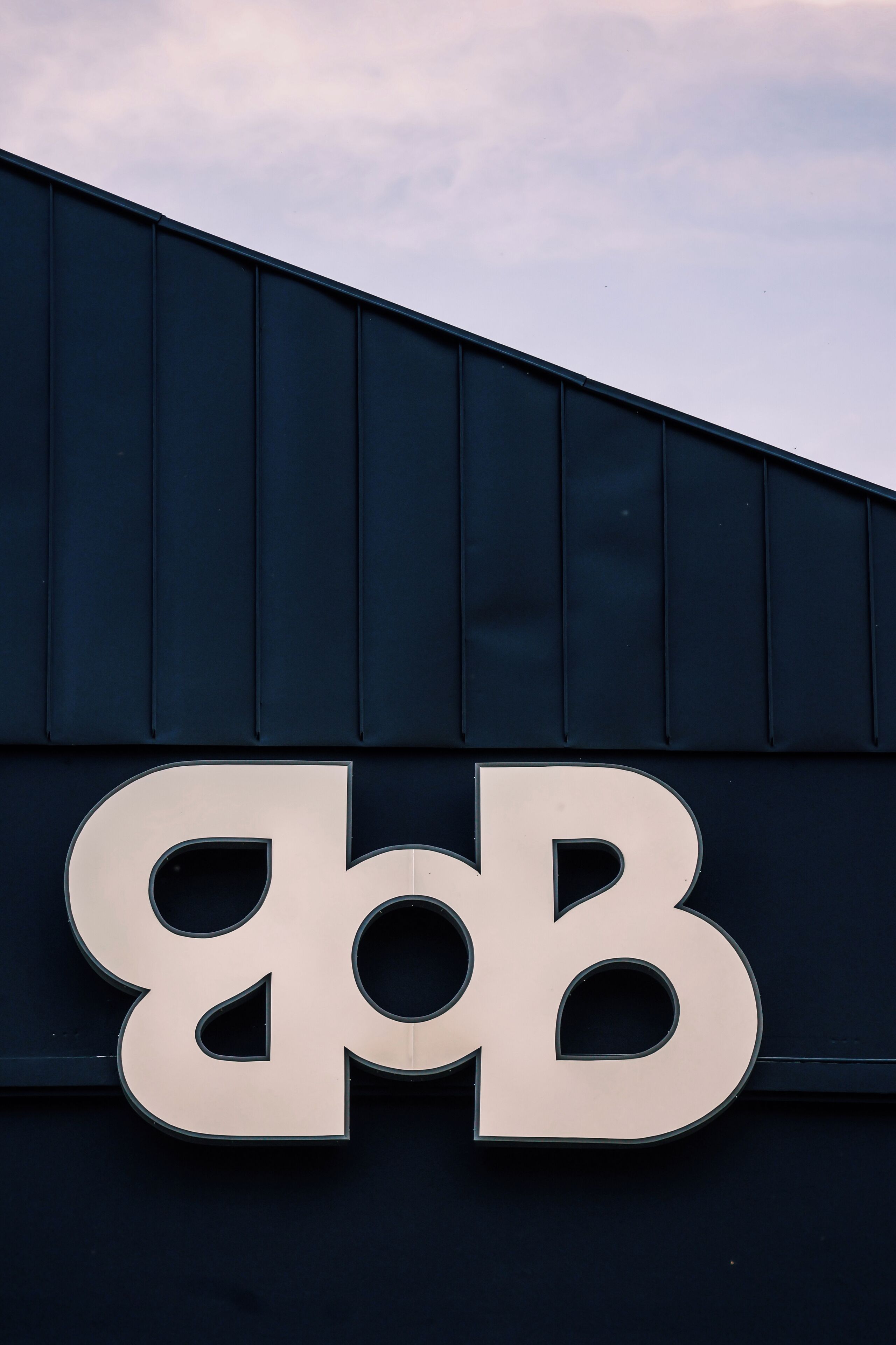 A building with a large, metallic sign featuring the letters "BB".