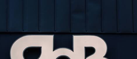 A building with a large, metallic sign featuring the letters "BB".