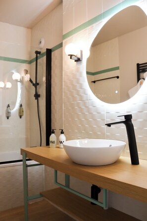 A modern bathroom with a white sink, black faucet, and a wooden vanity. - BEST OF BOTH (Divonne-les-Bains)