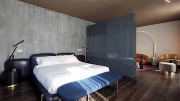 Un dormitorio moderno con una cama grande, un banco, un escritorio y una silla.