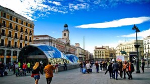 A public square with a large glass structure, historic buildings, and a clear sky. - Madrid - Studio Gran via 1C (Madrid)