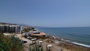 A coastal hotel with multiple buildings, a parking area, and a beach view. - Quiet and Luxurious Apartment on the Beach (Torrox)