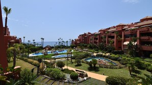 A resort with multiple swimming pools, palm trees, and a view of the sea. - Quiet and Luxurious Apartment on the Beach (Torrox)