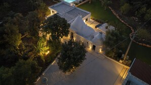 An aerial view of a modern house with a swimming pool, surrounded by trees and a well-maintained lawn. - LaCasa Apulia (Ceglie Messapica)