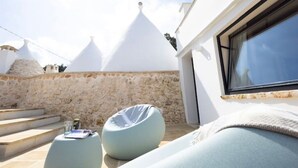 A rooftop terrace with a stone wall, a white building, and a window. - LaCasa Apulia (Ceglie Messapica)