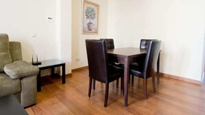 Un coin repas comprenant une table et des chaises, une petite table d’appoint et un canapé.