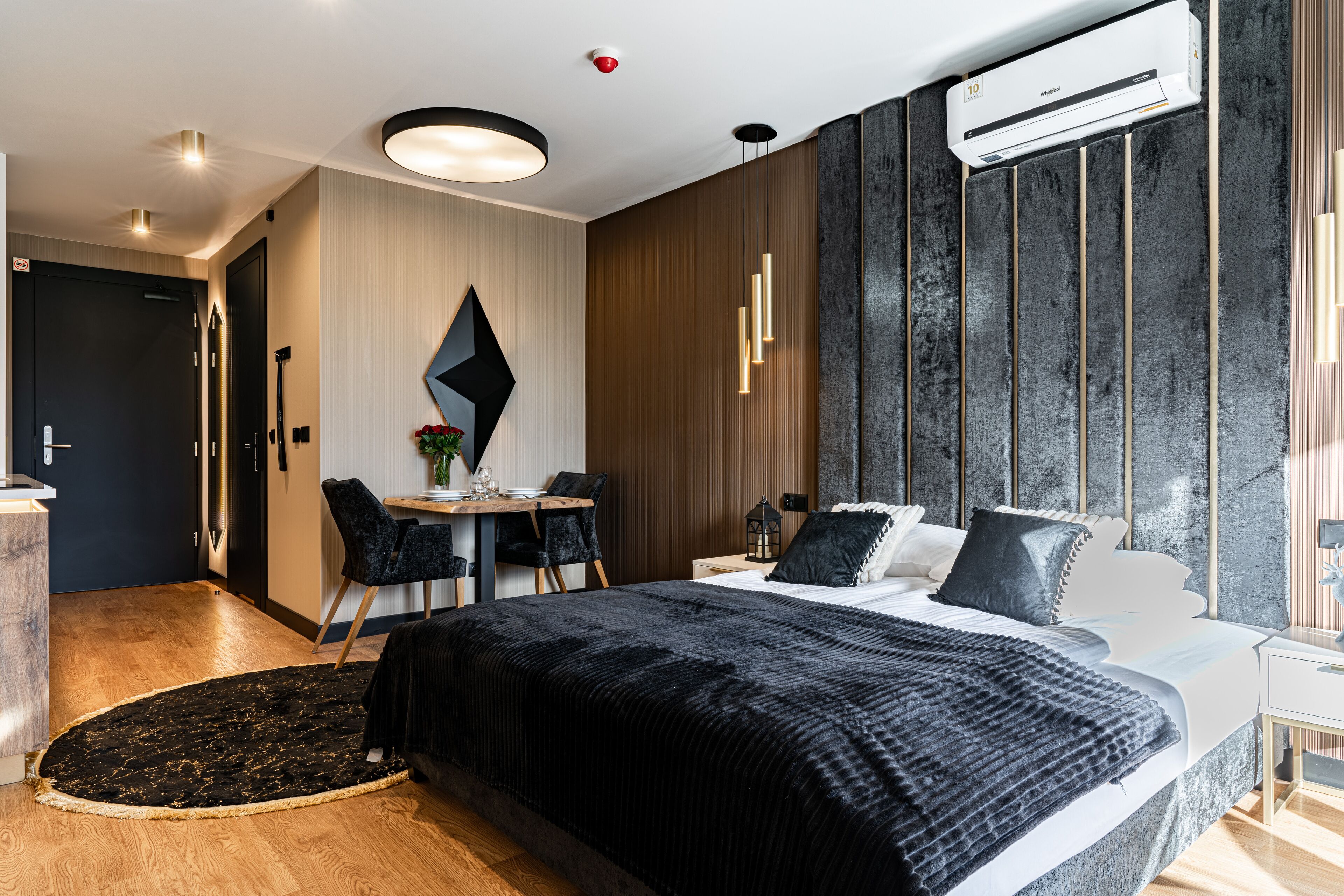 Una habitación de hotel moderna con una cama grande, un escritorio y un área de comedor.