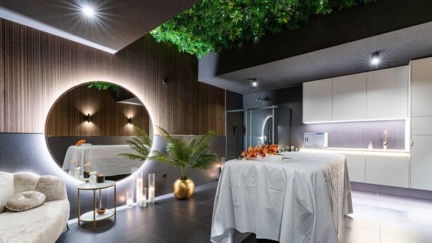 A modern hotel room with a round seating area, a dining table, and a kitchen area. - Aparthotel Diamond SPA Aqua (Bukowina Tatrzanska)