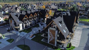 A modern residential area with a mix of traditional and contemporary architecture, featuring a central building with a unique facade and a spacious courtyard. - Aparthotel Diamond SPA Aqua (Bukowina Tatrzanska)