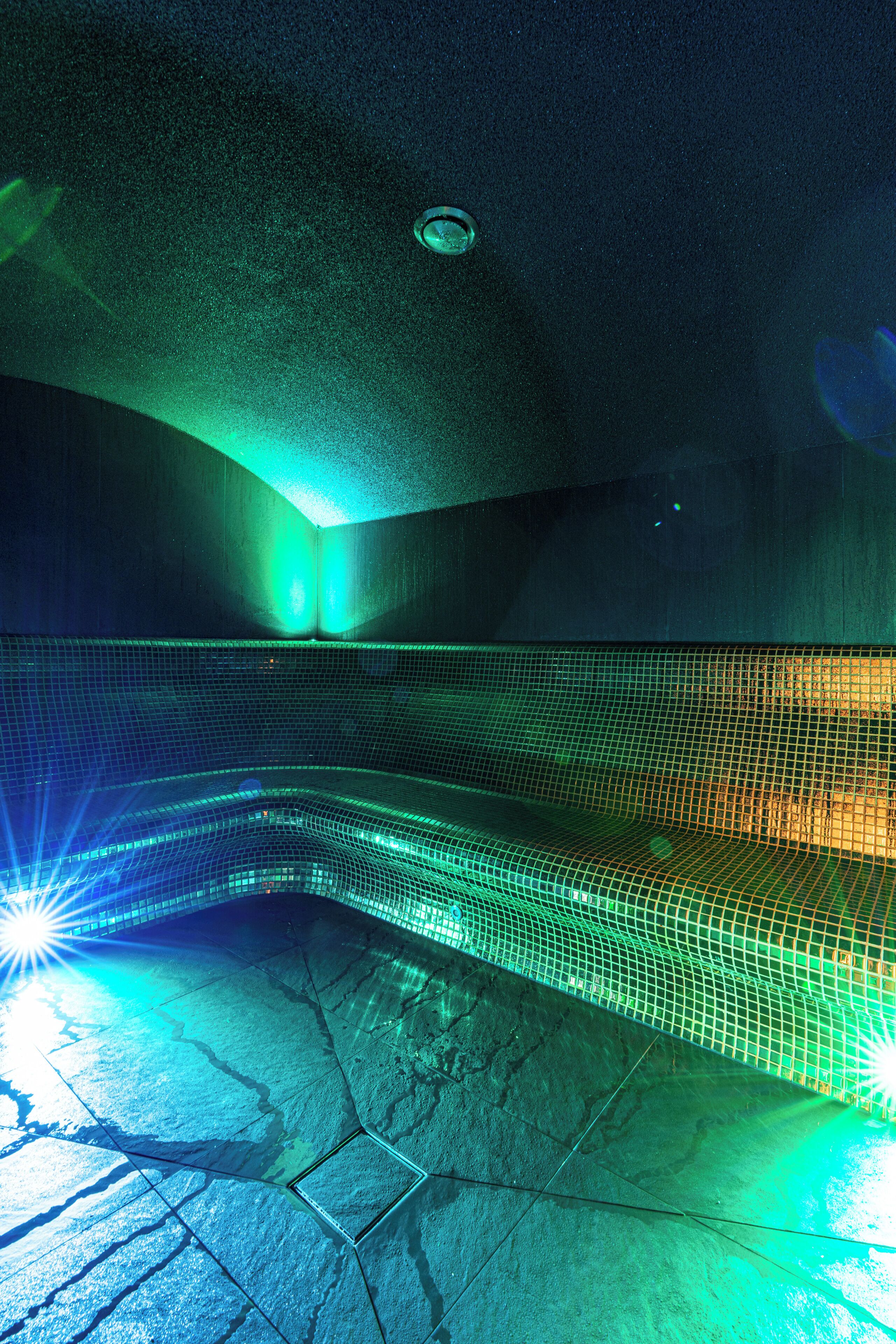 A room with a curved ceiling, a visible light fixture, and a patterned floor.